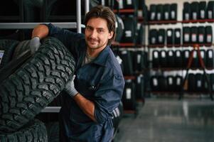Professional, worker is ,with wheel. Man is in the tire fitting car service photo