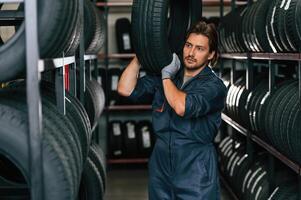 Carrying, the tire. Man is in the tire fitting car service photo