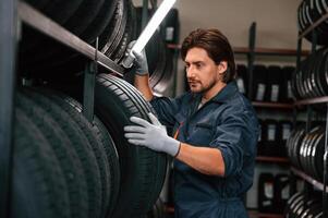 Work ,in,, progress,, manager is in warehouse. Man is in the tire fitting car service photo