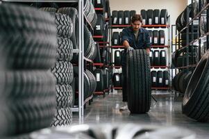 Rolling ,the, wheel. Man is in the tire fitting car service photo