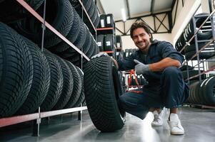 Positive ,facial expression. Man is in the tire fitting car service photo