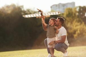 Happy facial expression, fun... Father and son are on the field together with toy plane photo