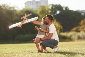 Joy, fun,,,, weekend activities. Father and son are on the field together with toy plane photo