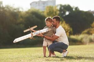 Joy, fun, weekend, activities. Father, and ,son are on the field together with toy plane photo