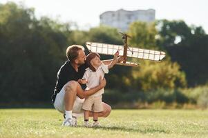 Playful mood. Father ,and, son ,are on the field together with toy plane photo