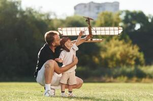 Playful mood. Father ,and, son are ,on the field together with toy plane photo
