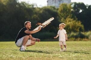 Father and son are on the field together with toy plane photo