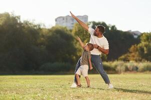 Flying ,hands gesture. Father and son are together on the field photo