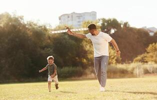 Running, fun. Father and son are ,on the field together with toy plane photo