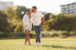 Front view.. Lovely couple are having a walk on the field photo