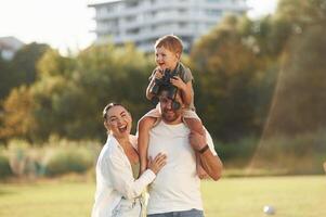 Looking far away, with binocular. Mother and father are with son outdoors on the field photo