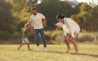 Leisure,, fun times. .Mother and father are with son outdoors on the field photo