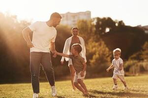 Parents with, two little sons are on the field together photo