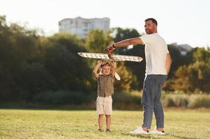 Happy, facial, expression, fun. Father and son are on the field together with toy plane photo