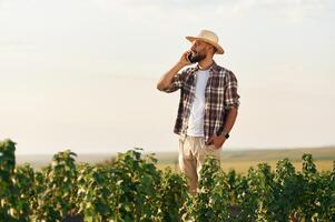Talking by a ,,phone. Farmer is on the agricultural field photo