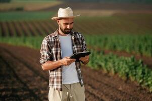 Digital tablet in hands., Farmer, is,, on the agricultural field photo