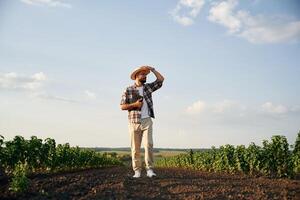 View, from, the ,front ,of him. Farmer is on the agricultural field photo