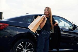 Right after ,the, shopping.. Woman is near her car outdoors photo