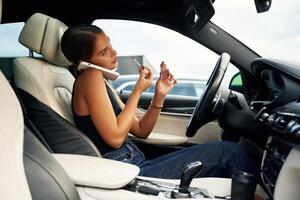 Side view,, talking by phone. Woman is sitting in the car photo