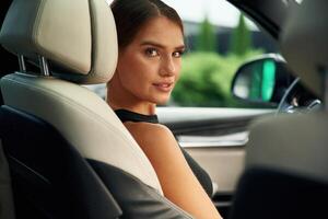 Looking back. Woman, is, sitting in the car photo