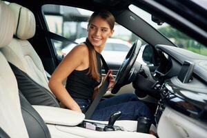 Wearing ,safety, belt. Woman is sitting in the car photo