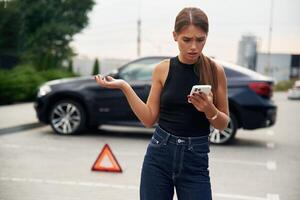 Trying to catch, the, signal and help by phone. Woman's car is broken, accident, standing outdoors photo