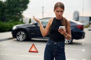 Trying to ,catch the signal and help by phone. Woman's car is broken, accident, standing outdoors photo
