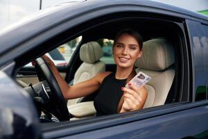 Showing ,,off with the driver's license. Woman is sitting in the car photo