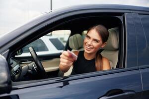 Showing ,off with the driver's license. Woman is sitting in the car photo