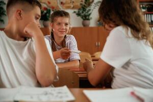 Taking ,the ,cheat sheet. Pupils, kids in the classroom together photo