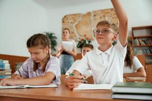 Focused,,, on the lesson. Pupils, kids in the classroom together photo