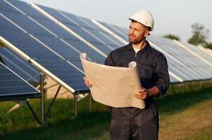 Man is working with solar panels outdoors at,, daytime photo