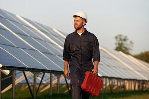 Case in the hand. Man is working with solar panels outdoors at daytime... photo
