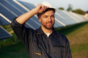 Handsome, guy, portrait. Man is working with solar panels outdoors at daytime.. photo