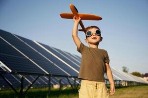 Time, to, fly., Aviator glasses and toy plane. Little boy is with solar panels outdoors photo