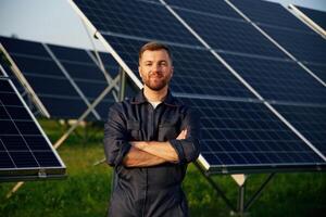 Portrait, standing with arms crossed...,, Man is working with solar panels outdoors at daytime photo