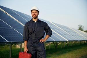 Case in ,the hand. Man is working ,,with, solar panels outdoors at daytime photo