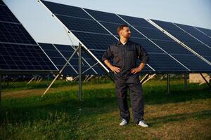 Taking ,a,,, break, standing. Man is working with solar panels outdoors at daytime photo