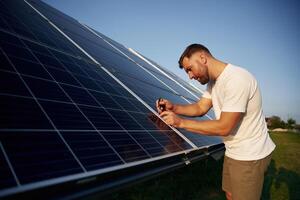 Man is working,, with solar panels outdoors at daytime photo