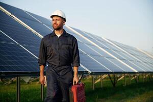 Case, in, the hand. Man is working with solar panels outdoors at daytime photo