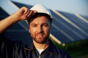 Taking ,a ,break,, standing. Man is working with solar panels outdoors at daytime photo