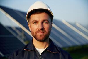 Taking a break, standing.. Man is working with solar panels outdoors at daytime photo