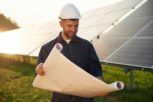 Pape,r plan, in, hands. Man is working with solar panels outdoors at daytime photo