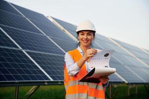 Female, worker engineer, in, uniform is near solar panels photo