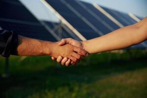 Close, up ,view of handshake against solar panels outdoors photo