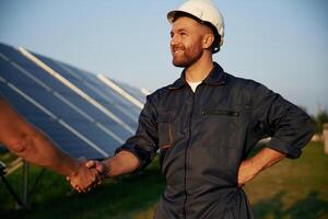 Man, is working with solar panels outdoors at daytime photo