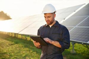 Reflection, of, the sunlight behind. Man is working with solar panels outdoors at daytime photo