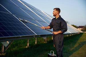 Keep it, clean., Man is working with solar panels outdoors at daytime photo