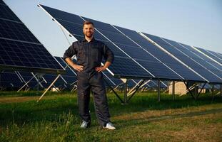 Handsome, guy portrait. Man is working with solar panels outdoors at daytime photo