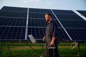 Keep,, it clean. Man is working with solar panels outdoors at daytime photo